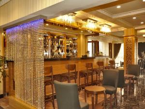 伊斯坦布尔阿尔法酒店的餐厅设有酒吧,配有椅子和葡萄酒瓶壁