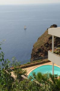 卡尼索美好地平线生活酒店的一艘在海洋中的帆船,拥有一座建筑和一个游泳池