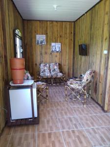 莫雷蒂斯Pousada Serra Verde Ecolodges的客厅配有两把椅子和电视