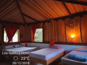 San MiguelLos Gallitos Eco Lodge的一间卧室设有两张床和木制天花板