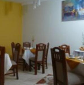 库斯科因卡伊拉酒店的用餐室配有桌椅和桌椅