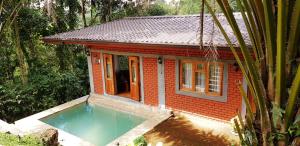 康提Tea Leaf Retreat的一座小房子,前面设有一个游泳池