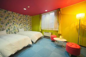 白马村HOTEL 24sweets HAKUBA的一间卧室配有两张床和一张桌子及椅子