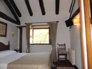 埃斯皮纳马波萨达马克西莫宾馆的一间卧室设有两张床、一个窗口和椅子