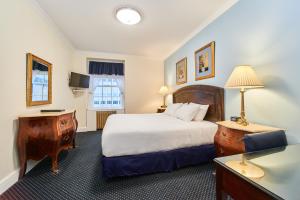 纽约西部三号俱乐部酒店的酒店客房设有一张大床和一张书桌。