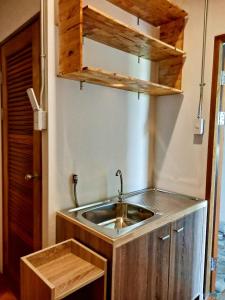清迈樱花之家旅舍的一个带水槽和木柜的厨房