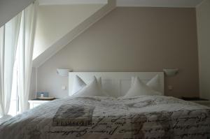梅灵Gästehaus Alt Mehring的白色的床、白色枕头和窗户