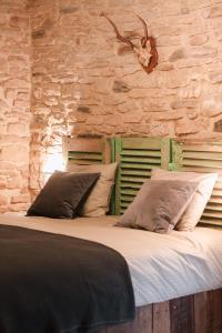 圣塞西尔Les Chambres du Chat的一张大床,位于一个石墙房间内
