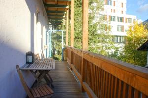 蓬高地区施瓦察赫Schwarzacherhof Pension & Apartments的阳台的门廊配有长凳和桌子
