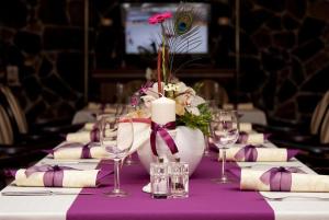 特伦钦Hotel Pod Hradom的一张桌子,上面有紫色的桌布,上面有蜡烛和鲜花