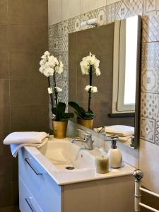 奥里斯塔诺Fra il Verde e l'Azzurro的浴室设有水槽、镜子和鲜花
