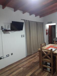 QuehuéDepartamento Teodelina的一间用餐室,配有一张桌子和一台墙上的电视