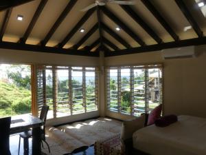 萨武萨武斐济沃萨尼阿山林小屋的客房设有床、桌子和窗户。