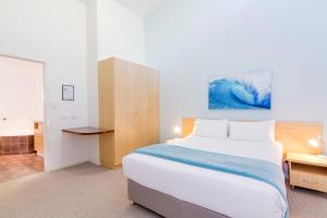 扬巴安格瑞度假酒店的一间卧室配有一张大床和一张书桌
