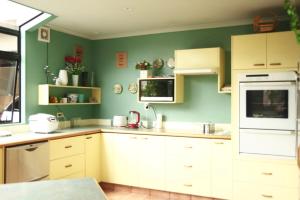 汉密尔顿Hamilton East Homestay的厨房配有白色橱柜和绿色墙壁