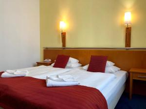 布达佩斯维瑞塔斯酒店的两张位于酒店客房的床,配有毛巾