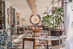 卢萨卡纬度15度酒店的一间设有桌椅的餐厅,种植了植物