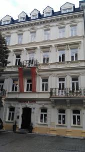 卡罗维发利萨多瓦公寓的一座带窗户和阳台的大型白色建筑