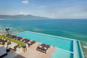 岘港TMS Hotel Da Nang Beach的享有游泳池和海洋的空中景致