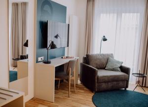 诺德奈Hotel Jann von Norderney的客厅配有椅子和书桌