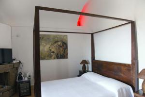 潘泰莱里亚唐马里奥度假村 的一间卧室配有一张天蓬床,墙上挂着一幅画作