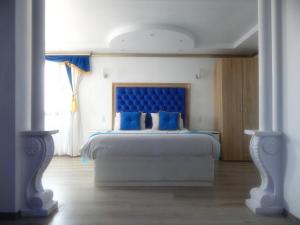 埃尔基斯科Hotel Boutique Castillo del Mar的一间卧室配有一张大床和蓝色床头板