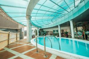 荣市孟坦比涅酒店的一座带玻璃天花板的建筑中的游泳池
