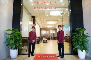 顺化Baly Hotel And Spa的站在大厅前的两个人