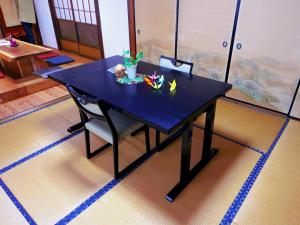 中津川市Guest House Motomiya的一张黑色桌子,上面放着一碗鲜花