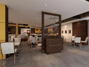 新山Grand Hallmark Hotel - Johor Bahru的餐厅设有镜子和桌椅