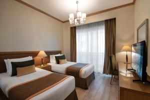 沙迦时光红宝石酒店式公寓的酒店客房设有两张床和一台平面电视。