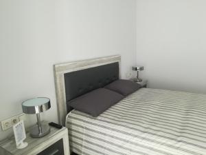 拉奥利瓦Marta & Lorenzo Apartment. Fuerteventura的一间卧室配有一张床和一张桌子上的两盏灯。