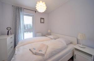 斯克拉斯卡波伦巴Apart-Invest Apartament Oslo的白色的卧室设有白色的床和窗户。