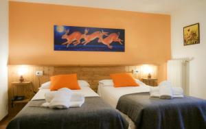 阿兰尼亚·瓦尔塞西娅尹德伦胡斯酒店的橙色墙壁的酒店客房内的两张床