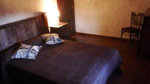 奥萨德蒙铁尔Casa Rural La Ossa的一间卧室配有一张带两个枕头的床