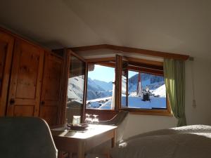 图克斯Pension Bergkristall的卧室设有窗户,享有白雪 ⁇ 的山景