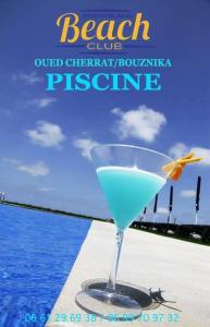 布兹尼盖Eden Island Villa - Bouznika的坐在海边的桌子上喝杯饮料