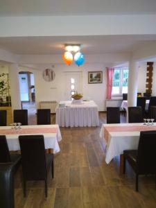库蒂纳LONJSKI DVORI的一间设有两张桌子和两个气球的用餐室