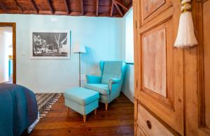 丰卡连特德拉帕尔马Casa Azul的一间卧室配有2把蓝色椅子、椅子和桌子
