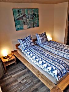 迈林根Churchstreet appartements的一张带蓝色和白色床单及枕头的床