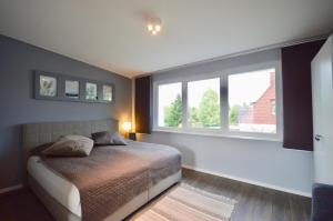 汉堡Urbaner Lifestyle im klimaneutralen Effizienzhaus的一间卧室设有一张床和两个窗户。