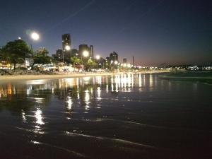 帕纳米林Natal RN Apartamento的夜晚享有海滩美景,配有灯光
