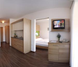 马伦格阿夸利斯公寓式酒店的一间卧室配有一张床,墙上配有电视