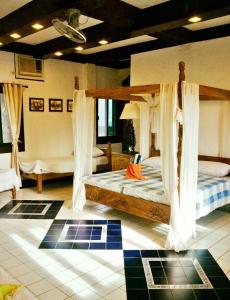 RomblonM Villa’s Farm Resort的一间卧室配有两张带窗帘的床