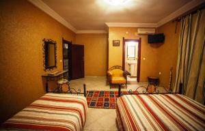 泰夫劳特Hotel Salama STE SAL- AMA SUD SARL AU的酒店客房,设有两张床和镜子