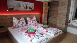 帕斯格许特路旁鲁斯巴赫瓦斯特尔之家公寓的一间卧室配有红色和白色枕头的床