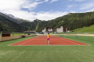 图克斯辛特图塞尔霍夫儿童与冰川酒店的一个人在网球场上