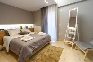 雅典M&D Luxury Suites in central Athens的一间卧室配有一张大床和镜子