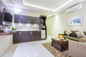 达瓦迪米Al Muhaidb Residence Al Dawadmi的带沙发的客厅和厨房