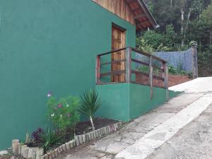 坎波斯杜若尔当Casa Estilo Kitnet的一座带窗户的蓝色建筑和一座植物